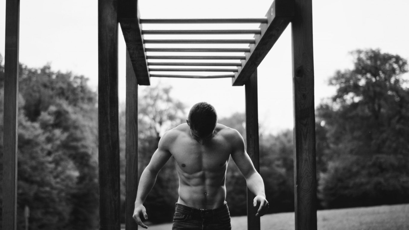 Мужчина занимается спортом на турнике