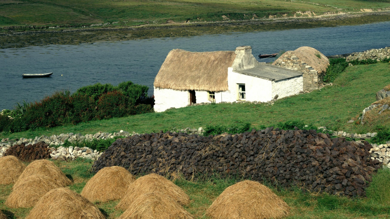 Покрытый соломой дом на берегу реки