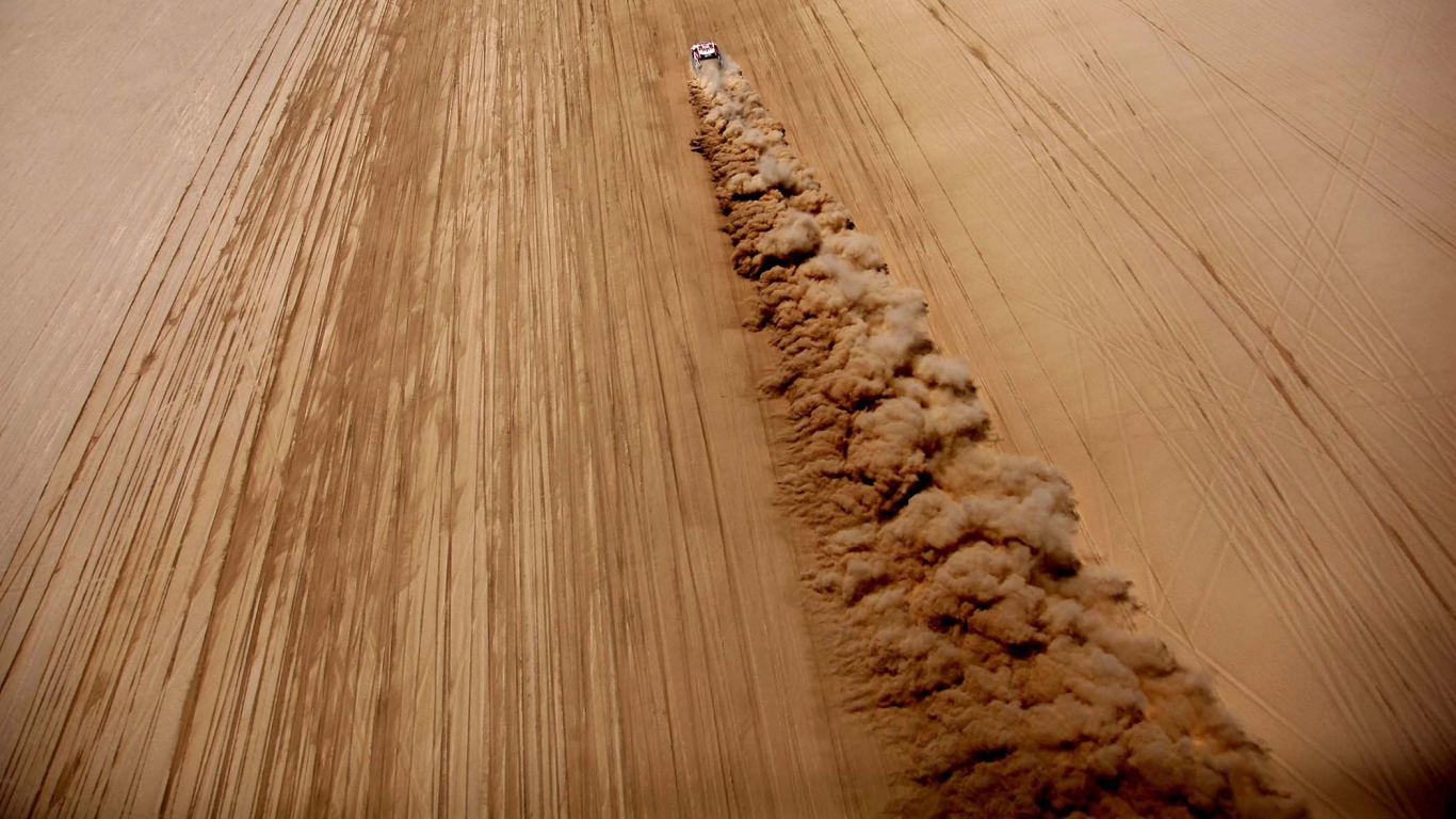 Облако пыли за автомобилем в пустыне