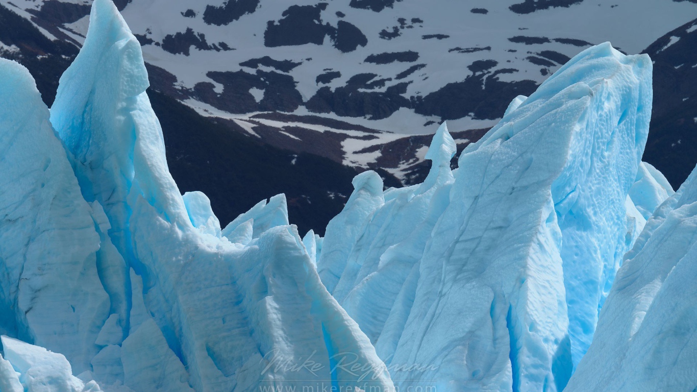 Глыбы голубого льда на фоне гор