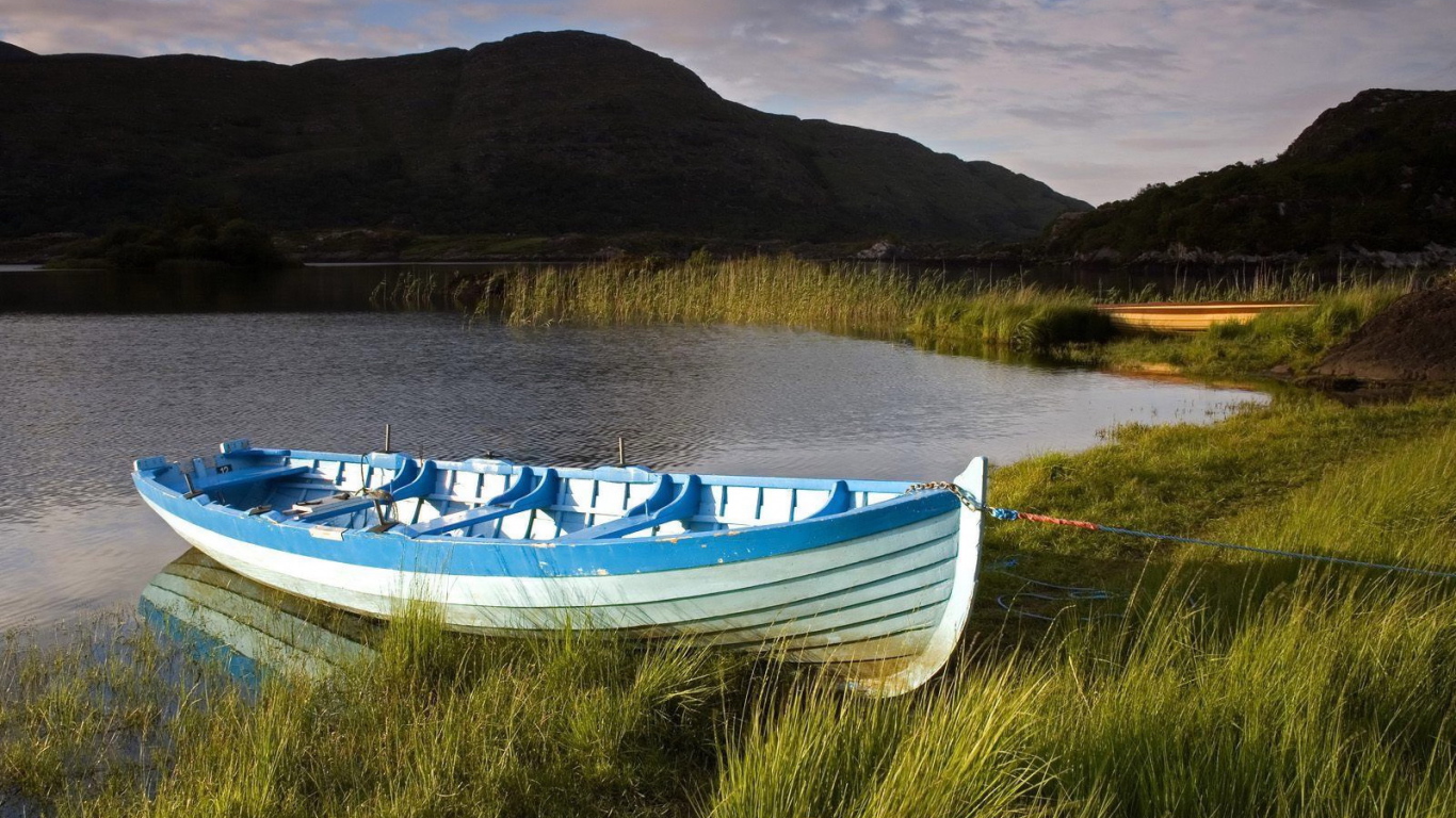 Синяя лодка на берегу озера