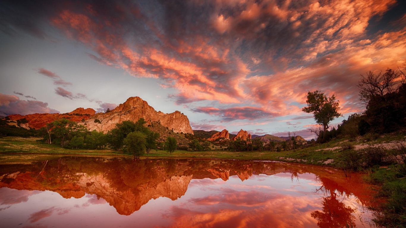 Облака отражаются в коричневой воде озера