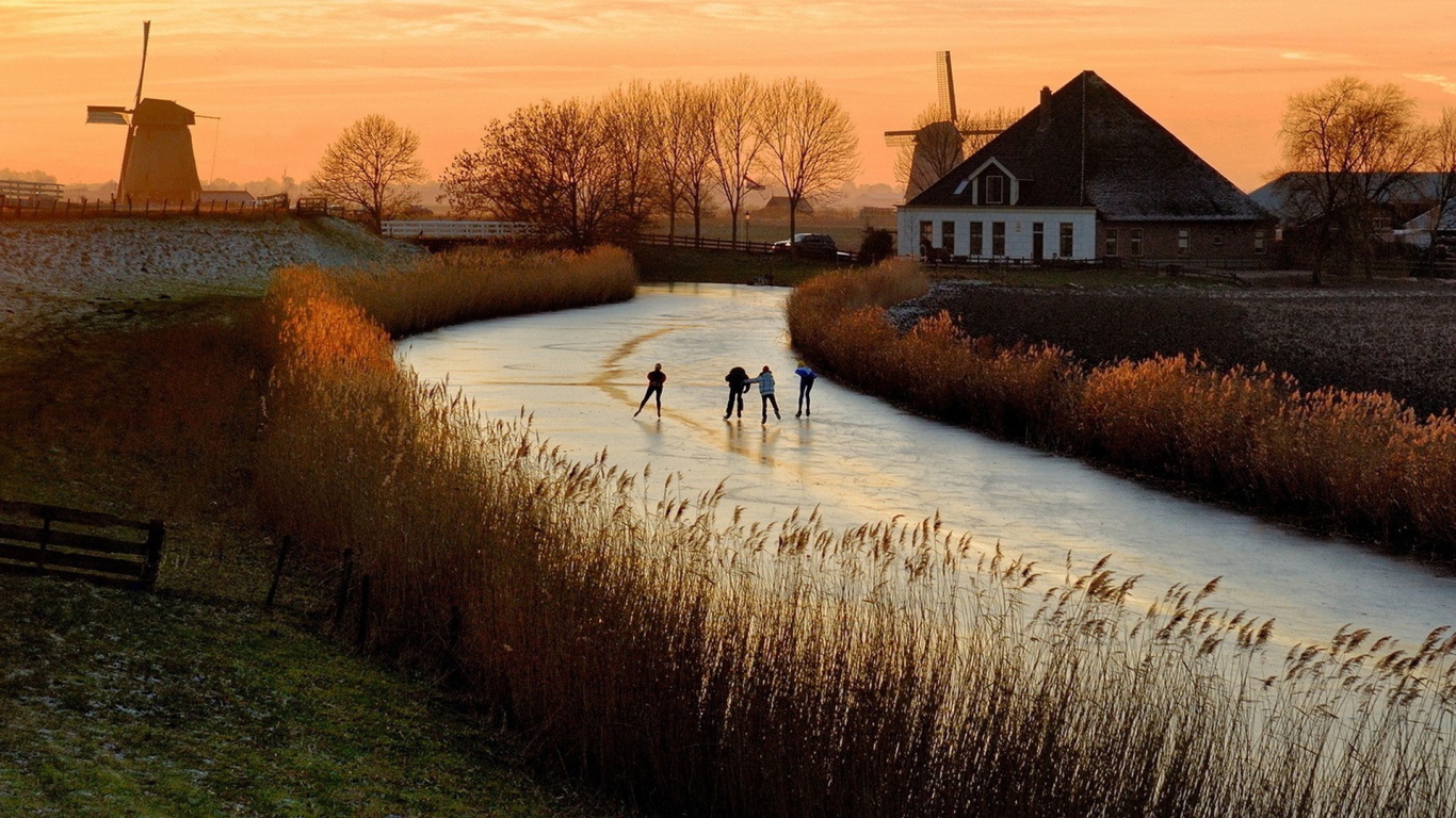 Дети катаются на коньках по замерзшей реке в Нидерландах