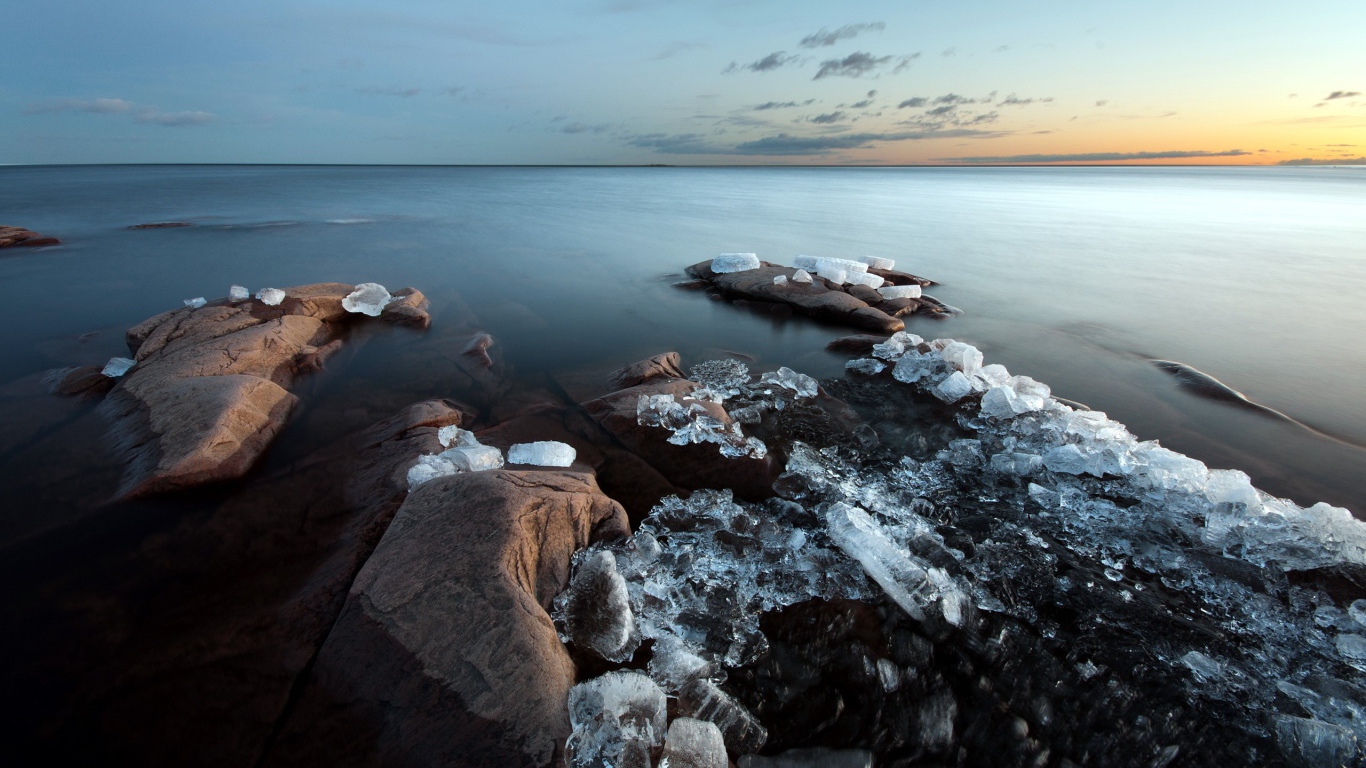 Куски льда на камнях у берега