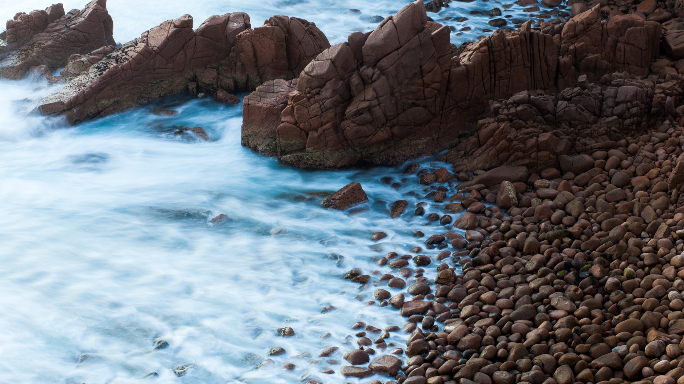 Мелкие коричневые камни на берегу моря
