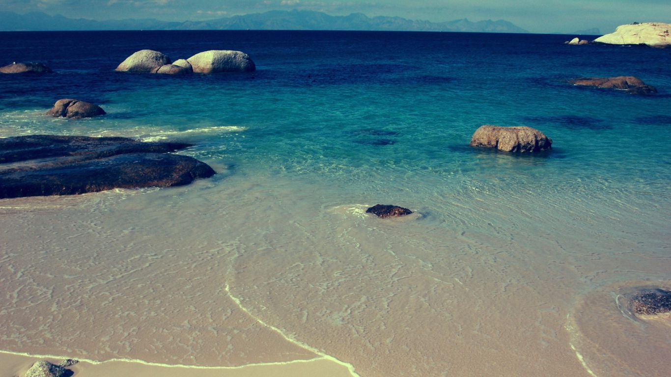 Камни в синей воде у берега моря