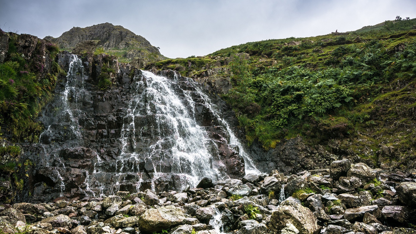Вода течет по камням с холма