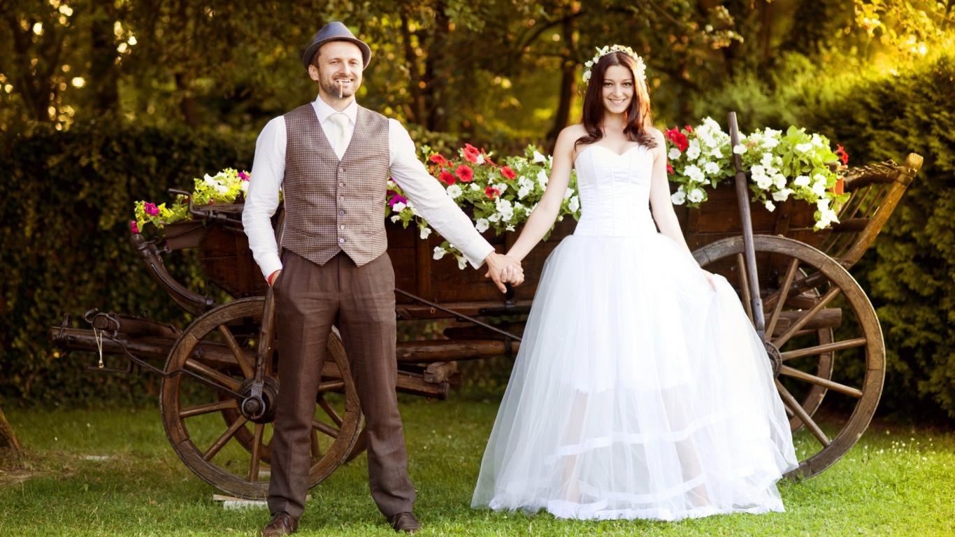 Жених и невеста на фоне телеги цветов