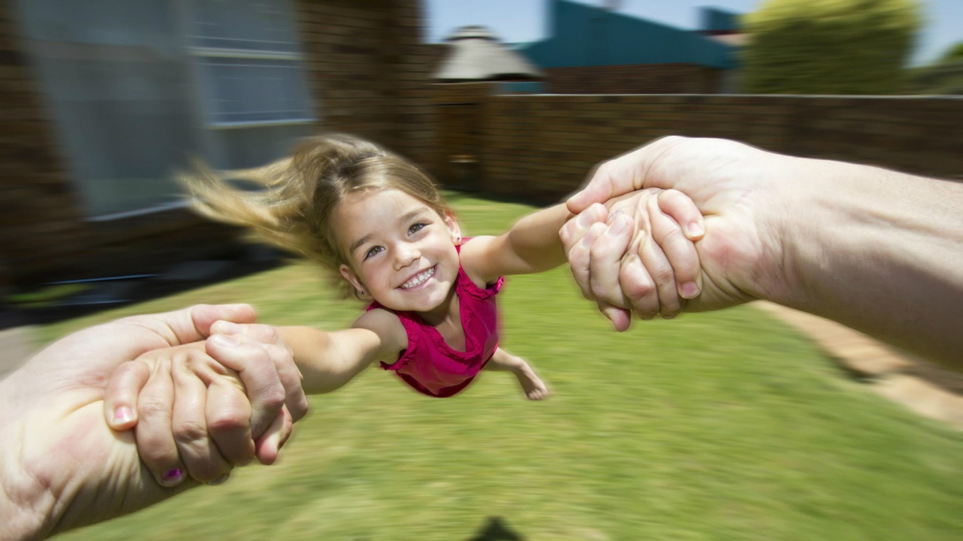 Веселая девочка в руках отца