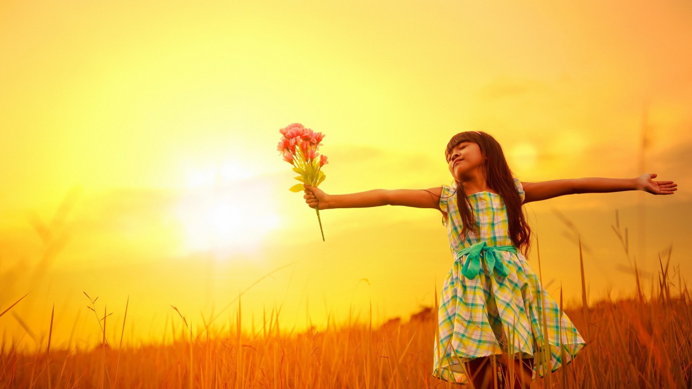 Девочка с букетом стоит в поле