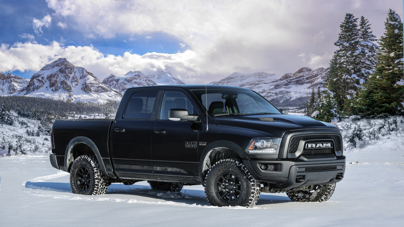 Автомобиль пикап Ram 1500 Rebel Black, 2017 года на фоне заснеженных гор 