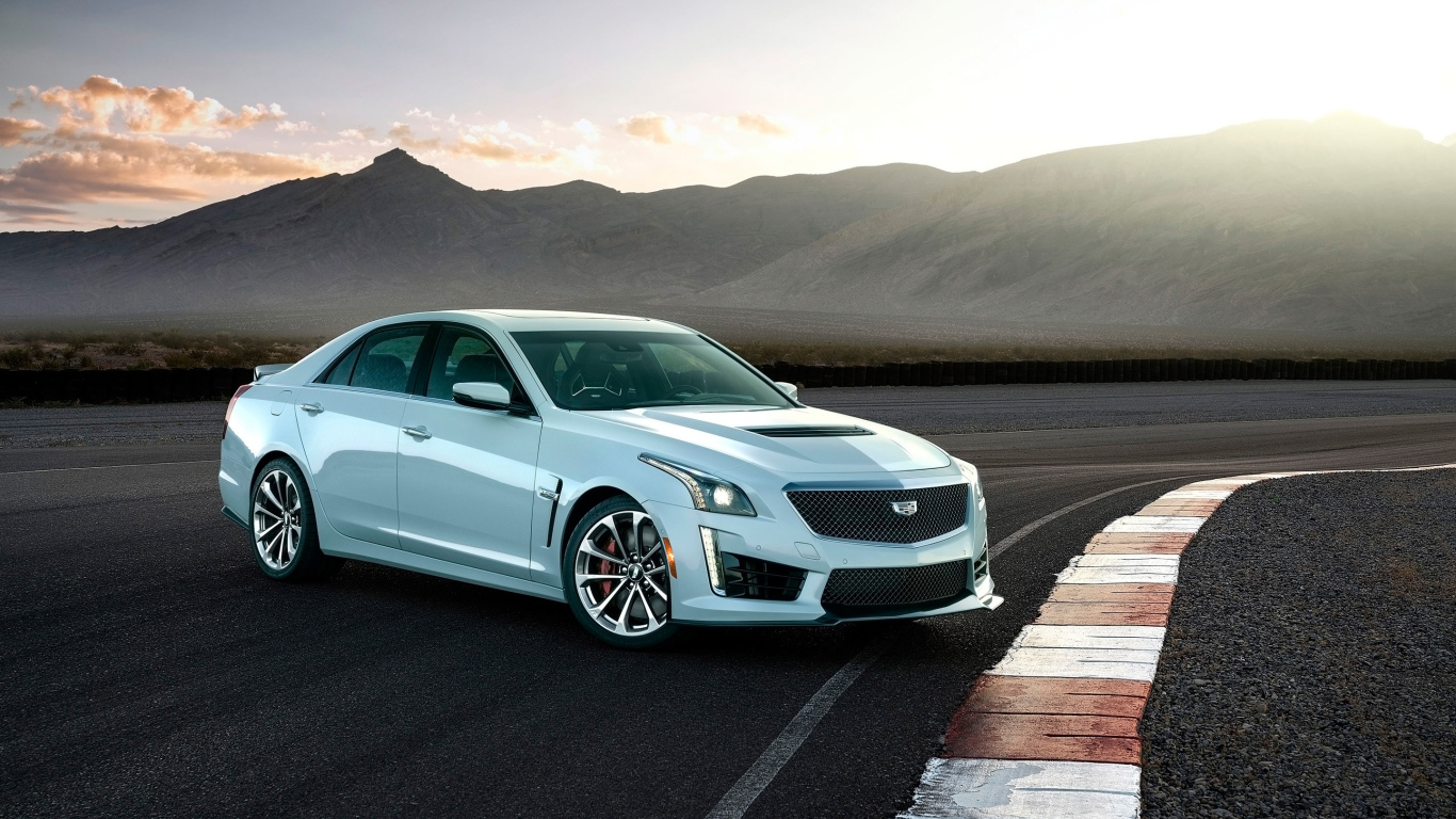 Белый автомобиль Cadillac CTS-V Glacier Metallic Edition, 2018 на фоне гор