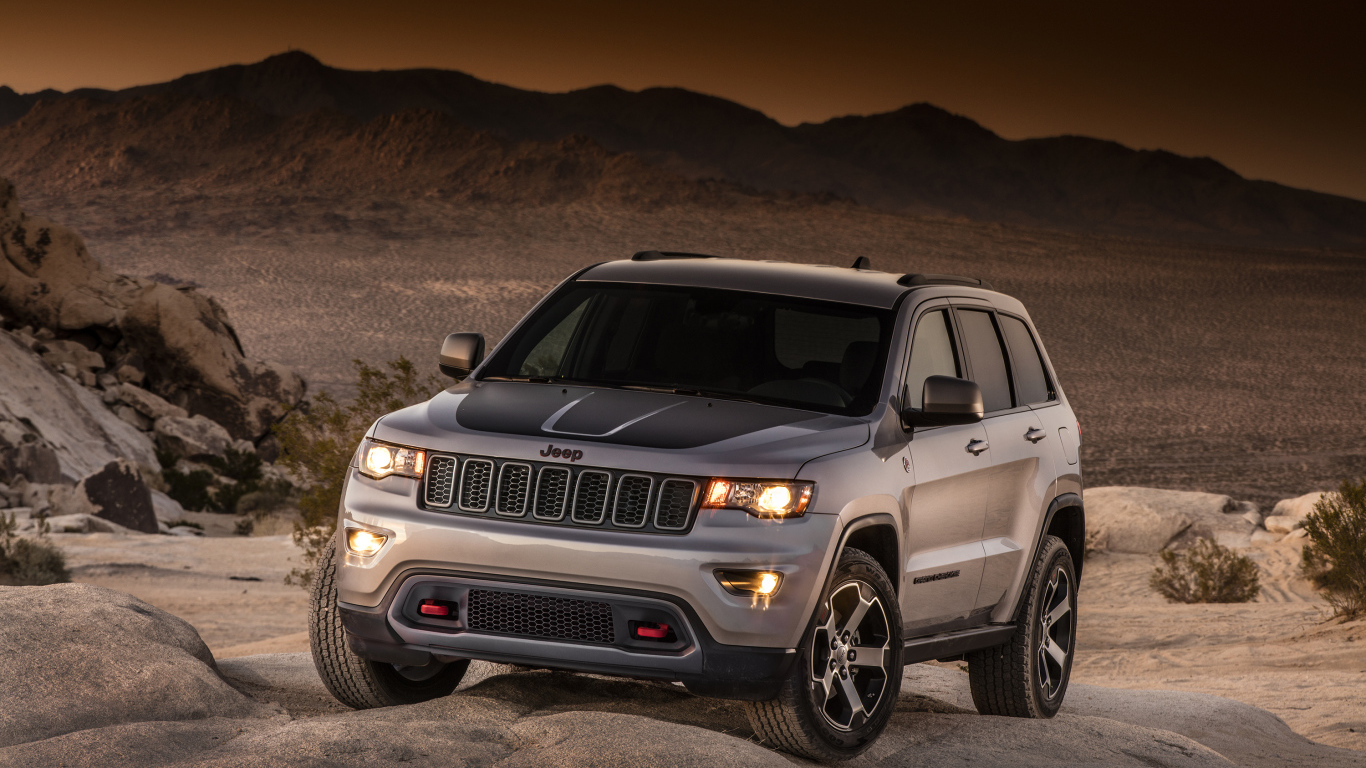 Серебристый внедорожник Jeep Grand Cherokee в пустыне 