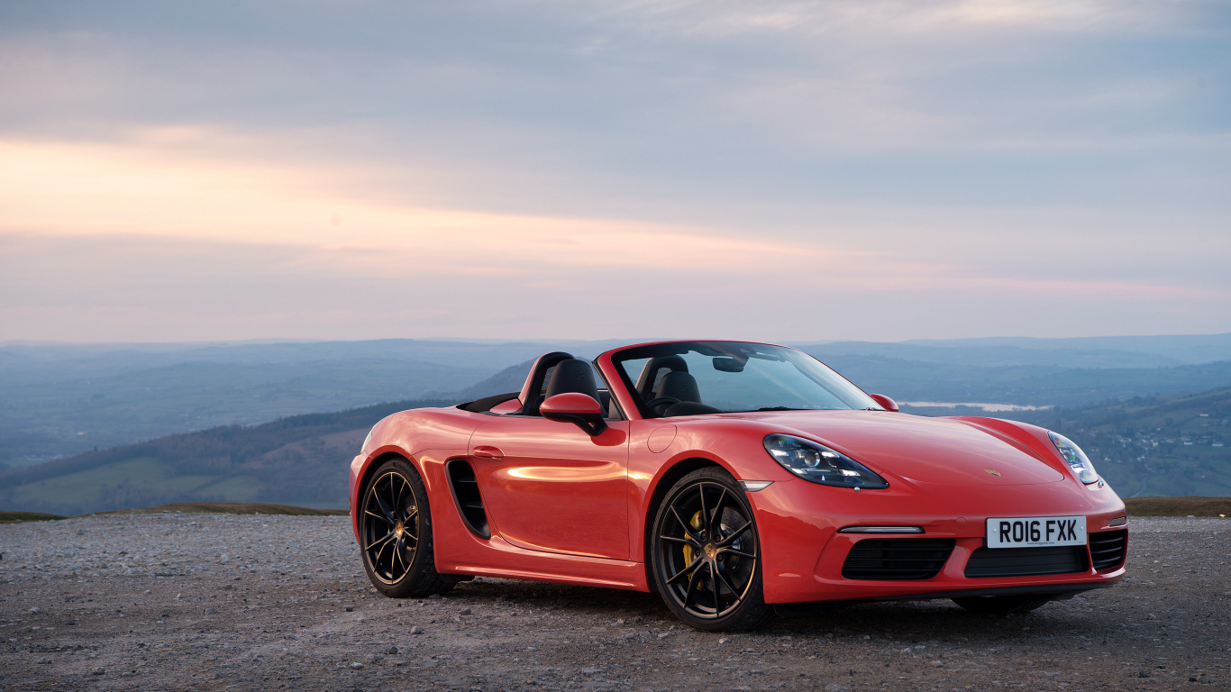 Красный автомобиль кабриолет Porsche 718 Boxster на фоне горизонта 