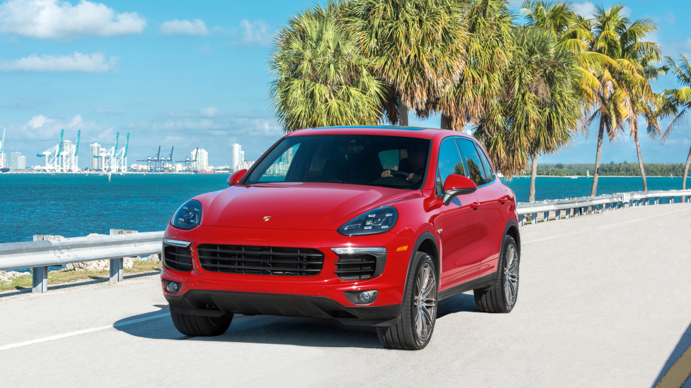 Красный внедорожник Porsche Cayenne на фоне океана