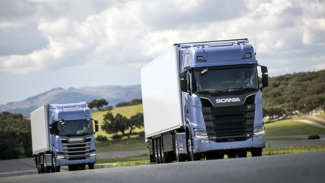 Два голубых грузовика Scania S 700 на трассе