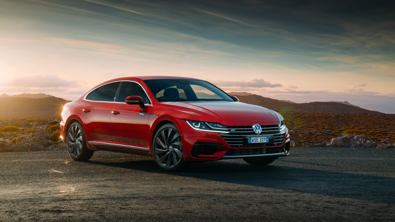 Красный автомобиль Volkswagen Arteon 4MOTION R Line, 2018 на фоне красивого неба