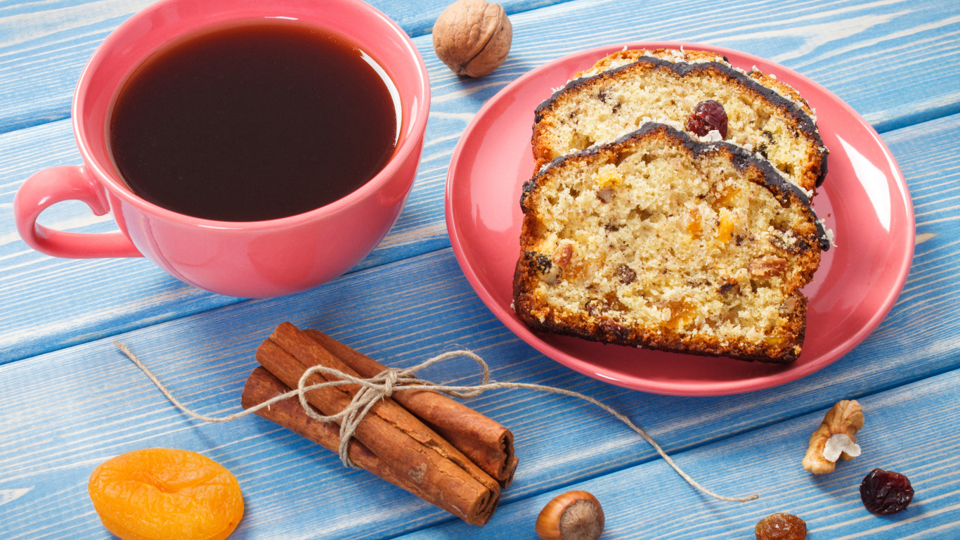 Кекс с корицей, орехами и курагой на столе с чашкой чая