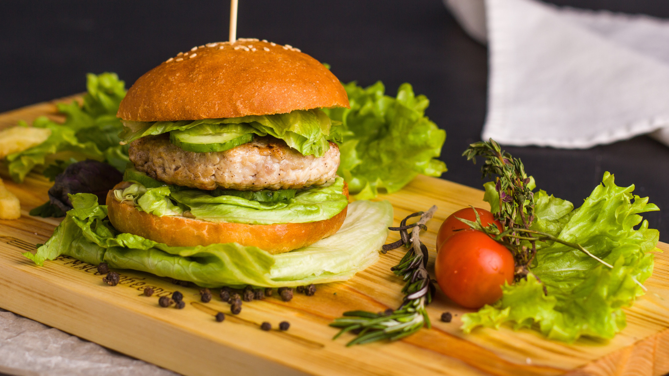 Гамбургер с зеленью на разделочной доске  