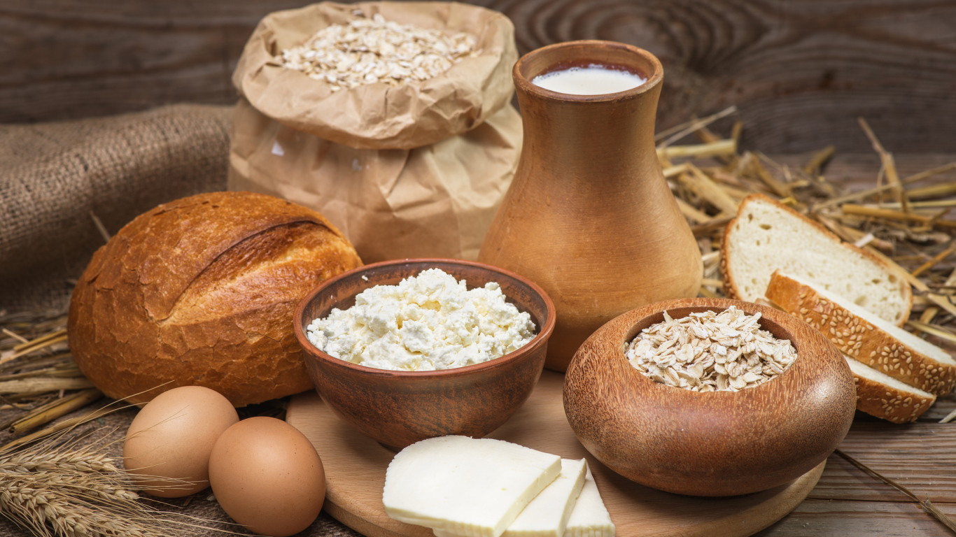 Натюрморт сыр, хлеб, яйца и молоко на столе 