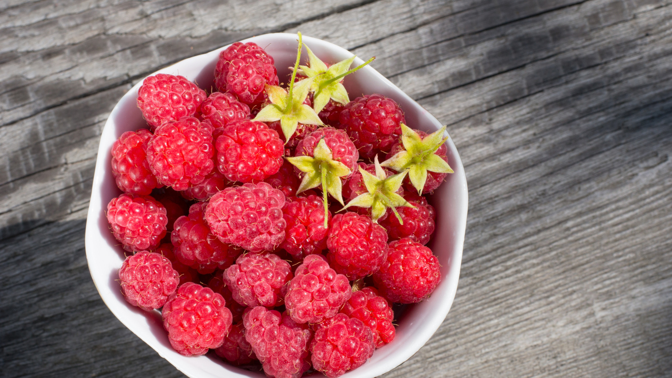 Аппетитная сочная свежая малина в белой тарелке 