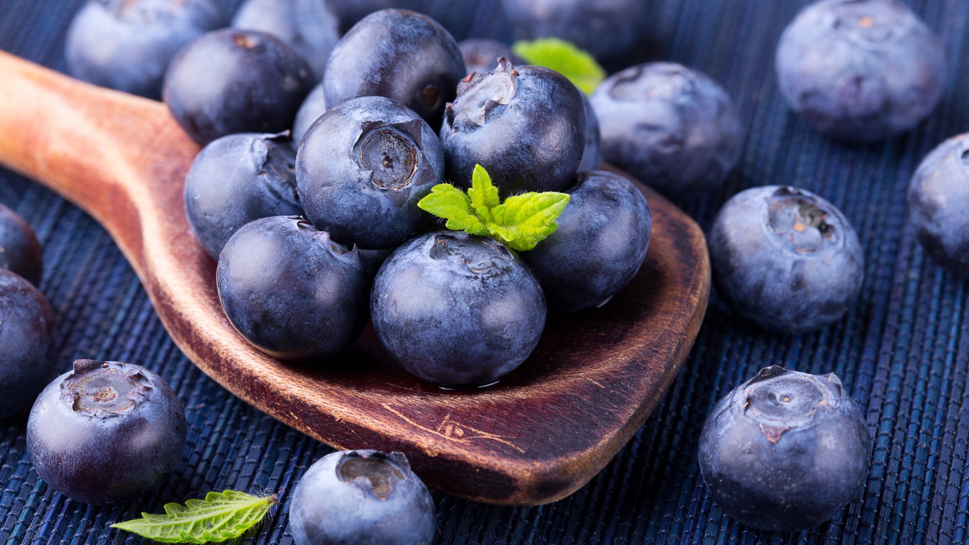 Ягоды спелой черники на деревянной ложке крупным планом