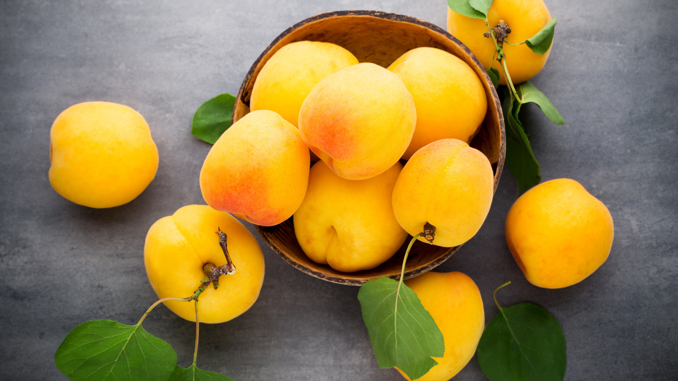 Крупные свежие желтые абрикосы на столе