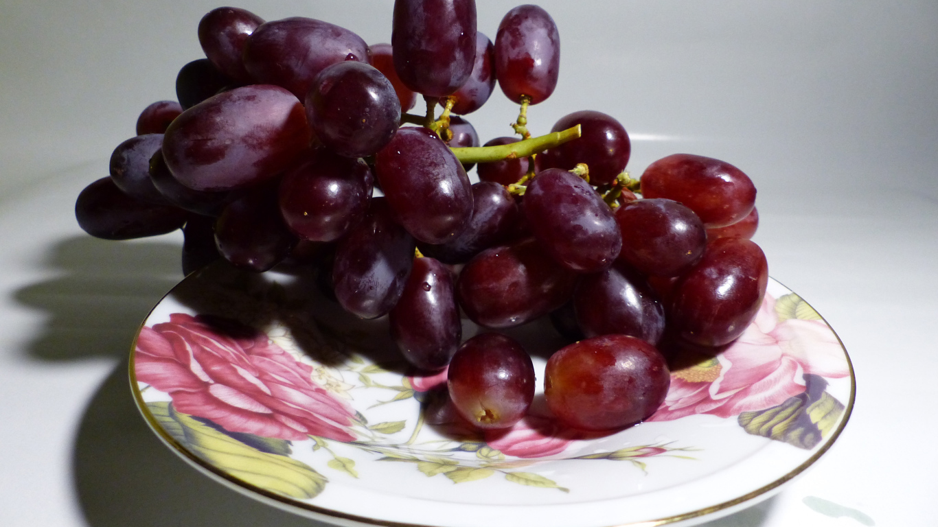 Розовый виноград на тарелке крупным планом