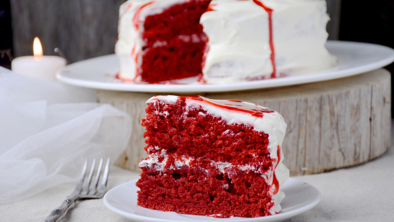 Кусок торта красного цвета с белым кремом 