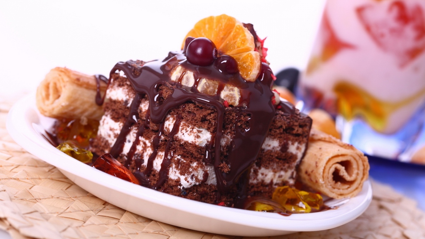 Аппетитное пирожное с шоколадной глазурью, трубочками и мандаринами