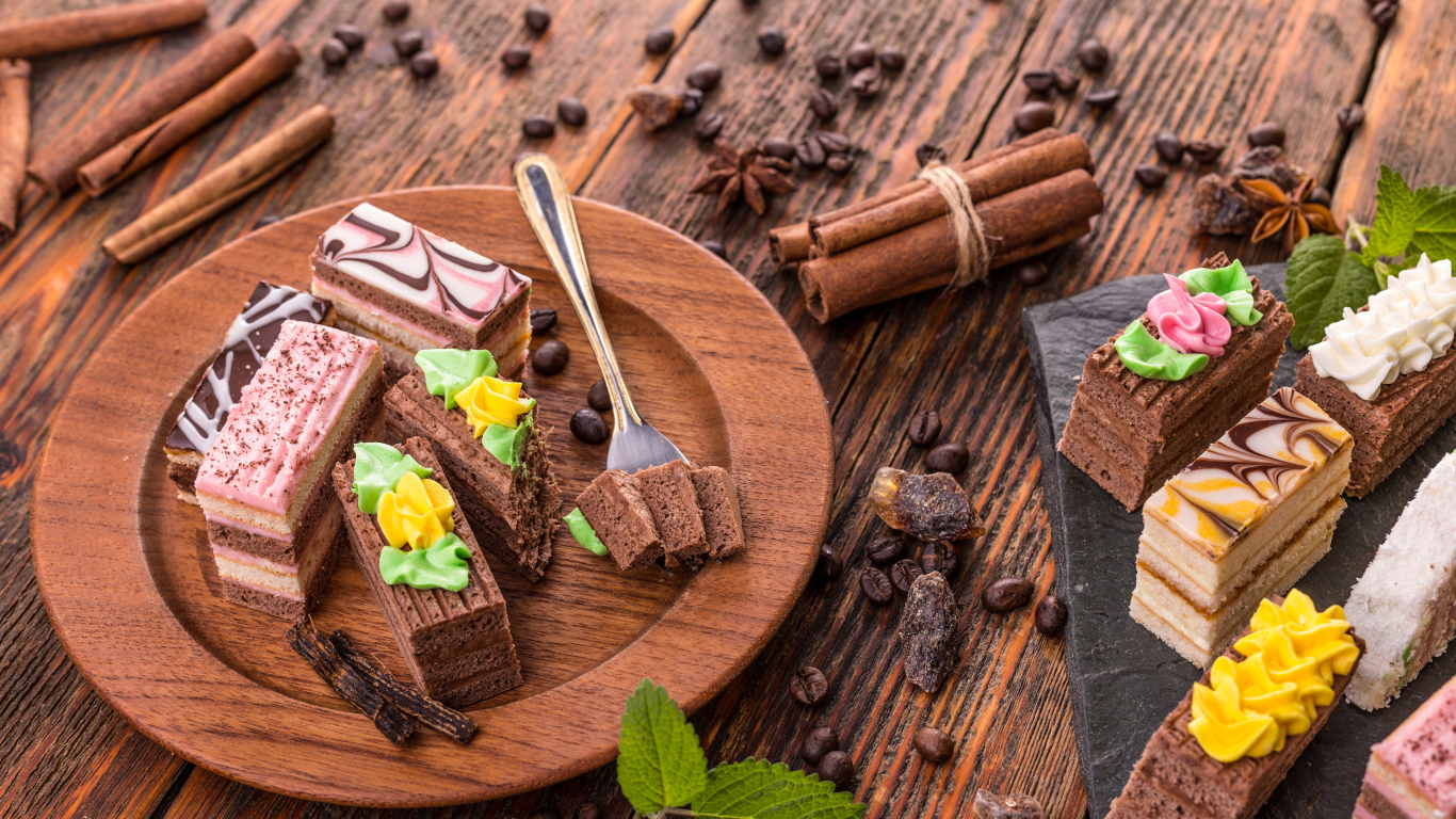 Аппетитные пирожные с зернами кофе и корицей на столе