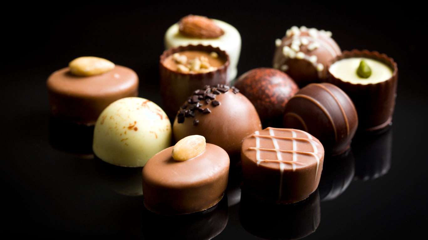 Аппетитные шоколадные конфеты на черном фоне