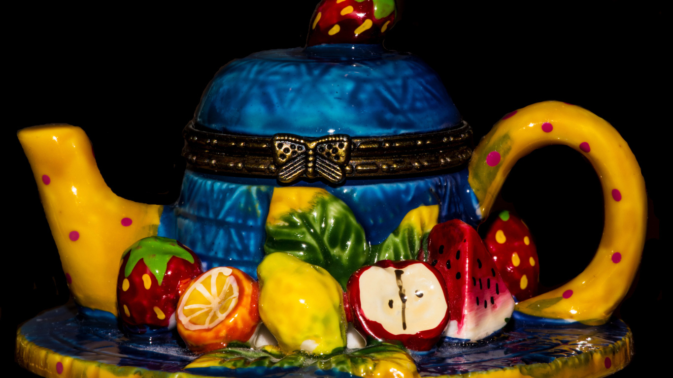 Красивый торт в виде чайника на черном фоне 