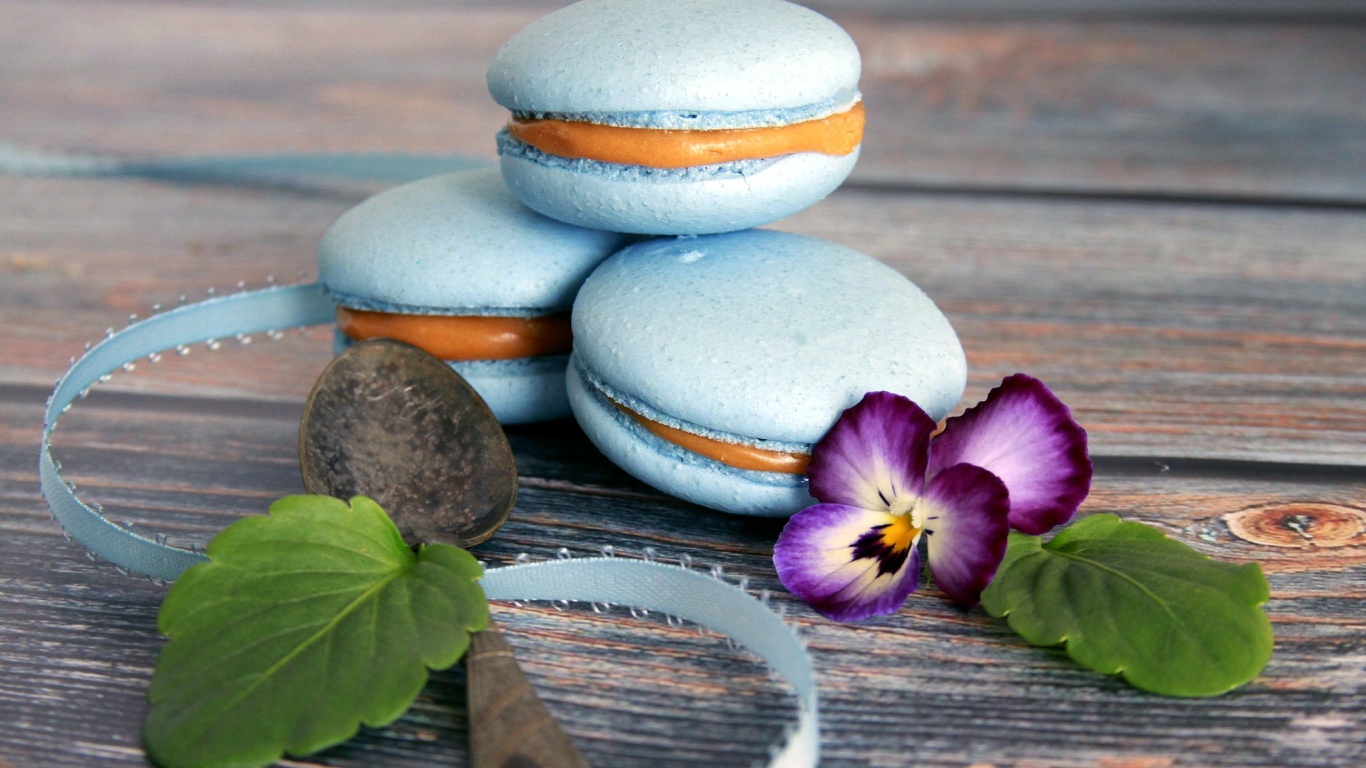 Голубые макаруны на столе с цветком 