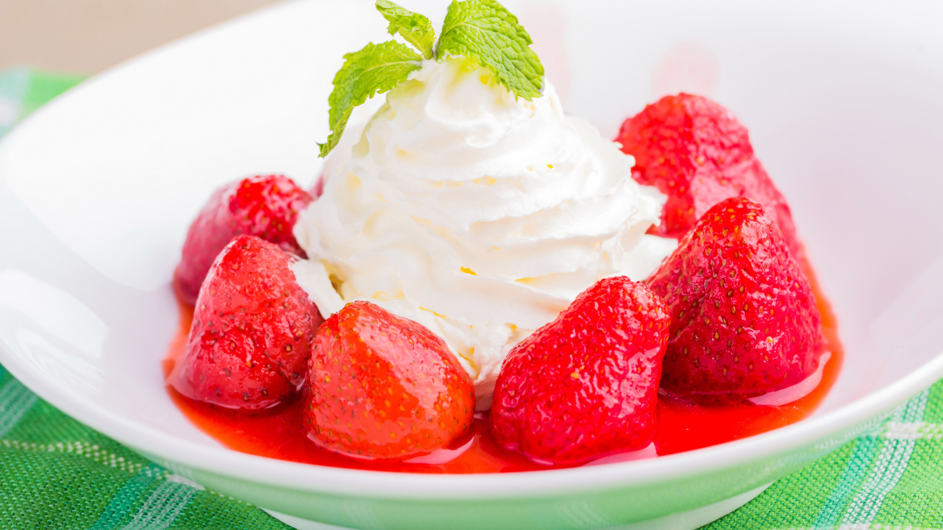 Вкусные сливки с клубникой на белой тарелке