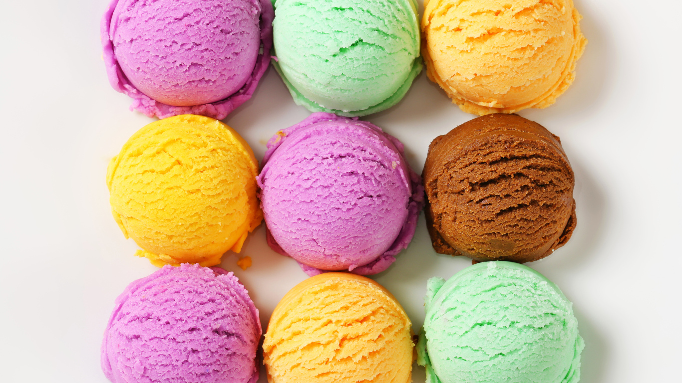 Разноцветные аппетитные шарики мороженого на белом фоне