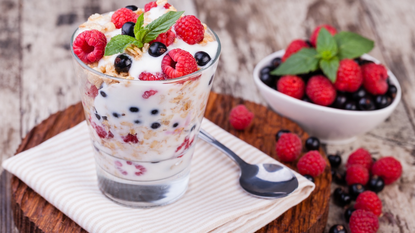 Сладкий десерт с овсяными хлопьями, йогуртом и ягодами малины и смородины