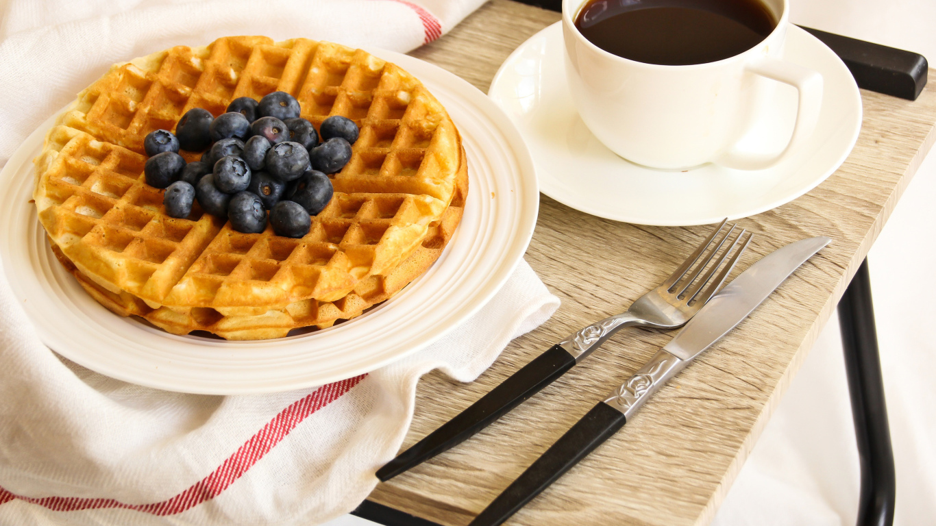 Сладкие вафли с черникой и чашкой кофе на завтрак