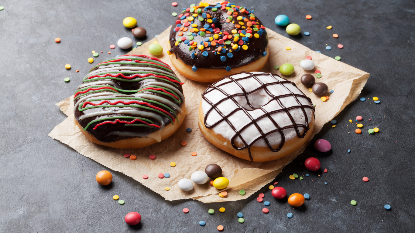 Три аппетитных сладких пончика с конфетами 