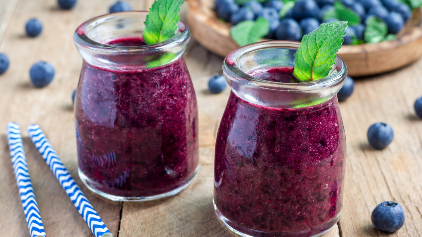 Вкусный черничный смузи с ягодами свежей черники на столе