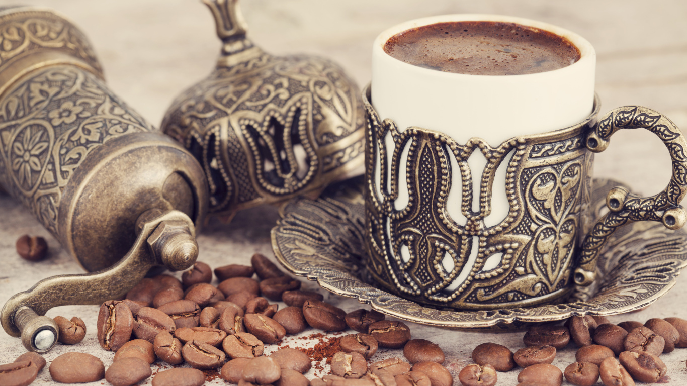 Вкусный кофе в красивой чашке с кофейными зернами на столе