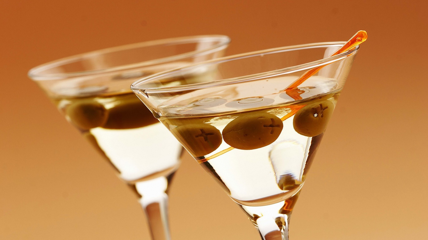 Напиток мартини в бокалах с оливками на кремовом фоне