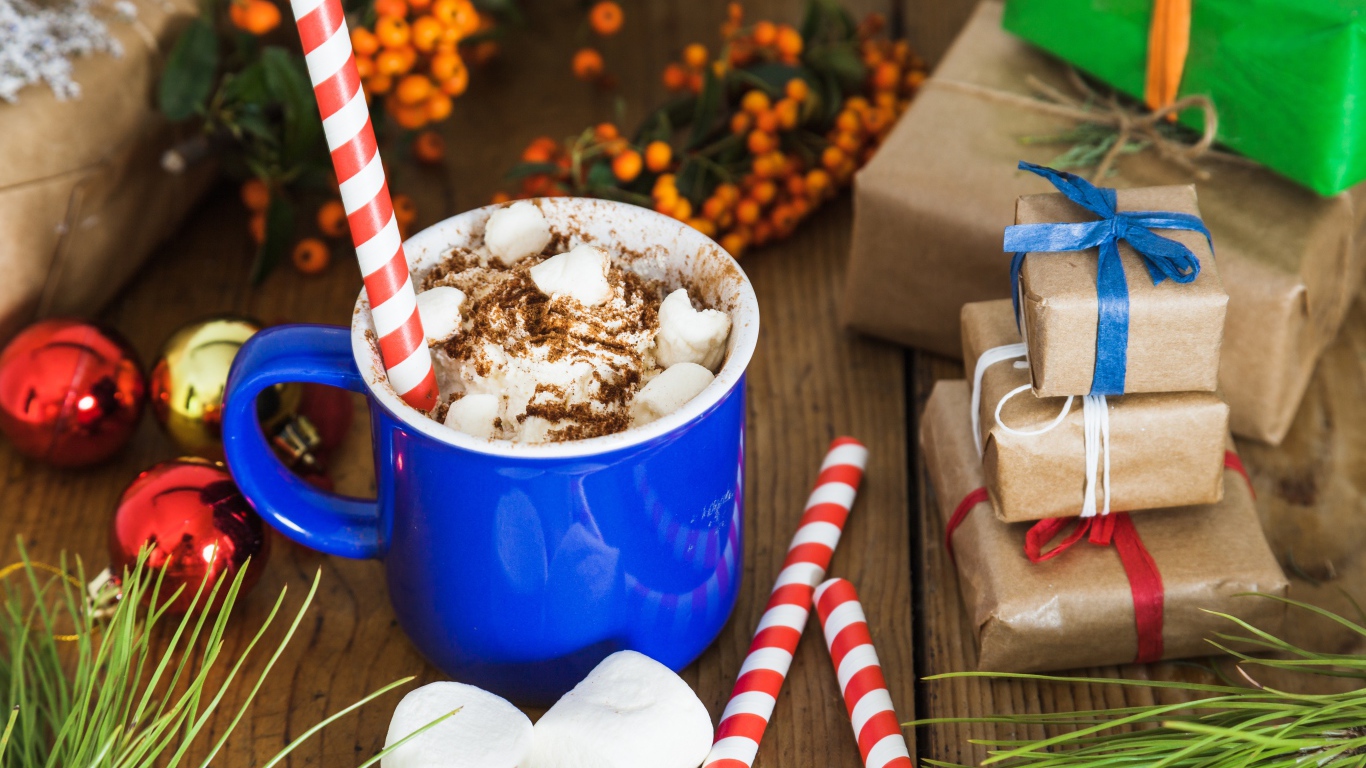 Сладкий напиток с маршмеллоу на столе с подарками на Новый год