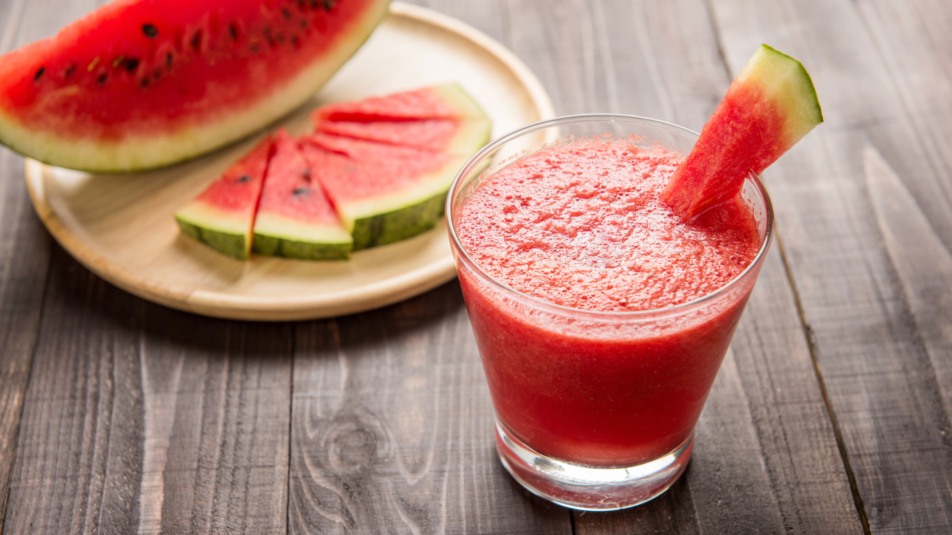 Арбузный смузи в стеклянном стакане с кусочками арбуза