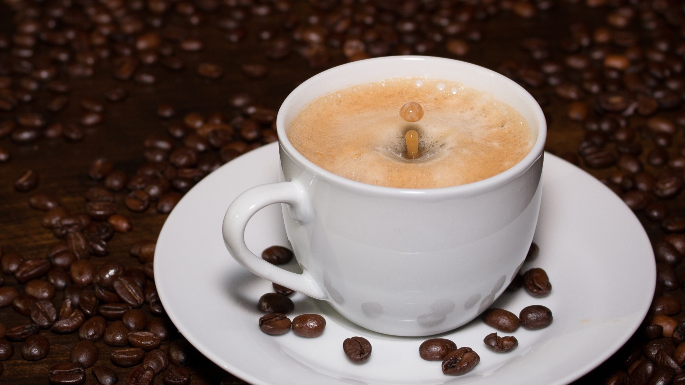 Белая большая чашка кофе с зернами на столе