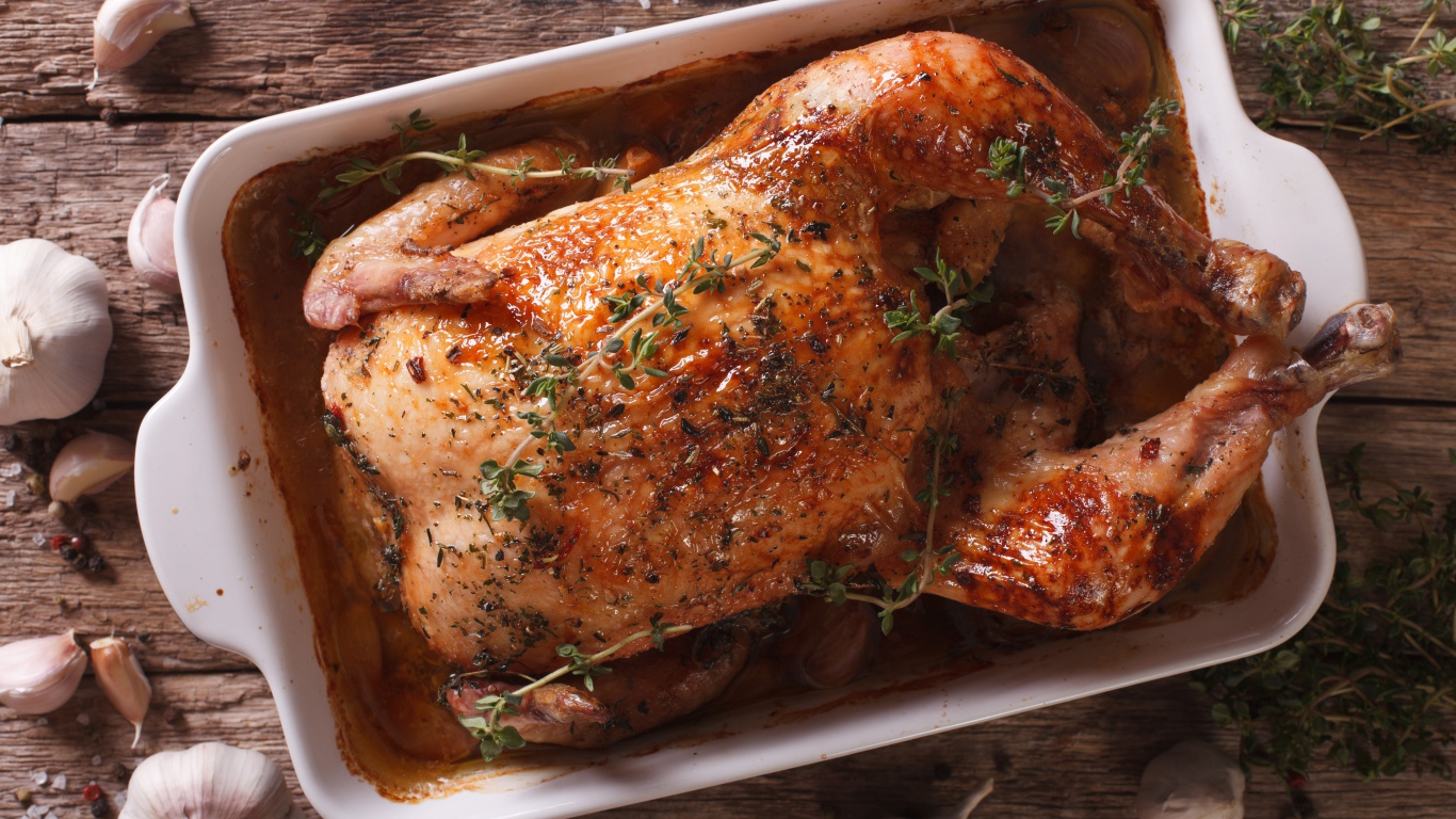 Запеченная аппетитная курица на со специями на столе