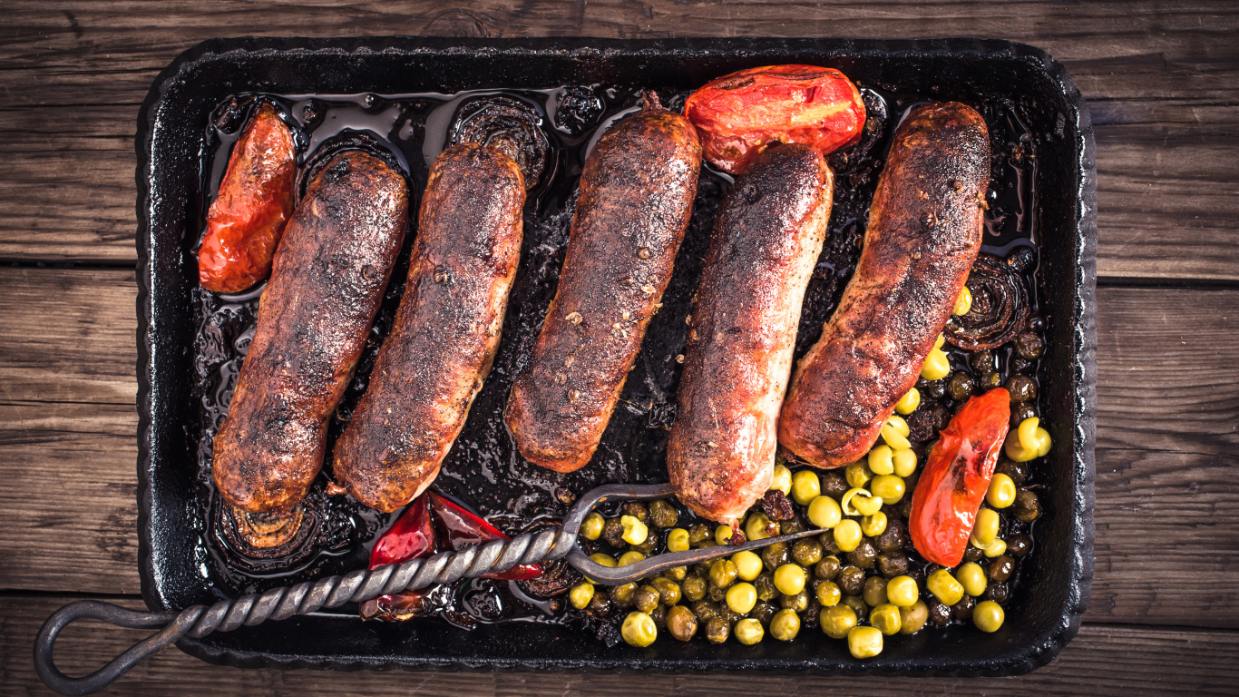 Жареные аппетитные сосиски с овощами 