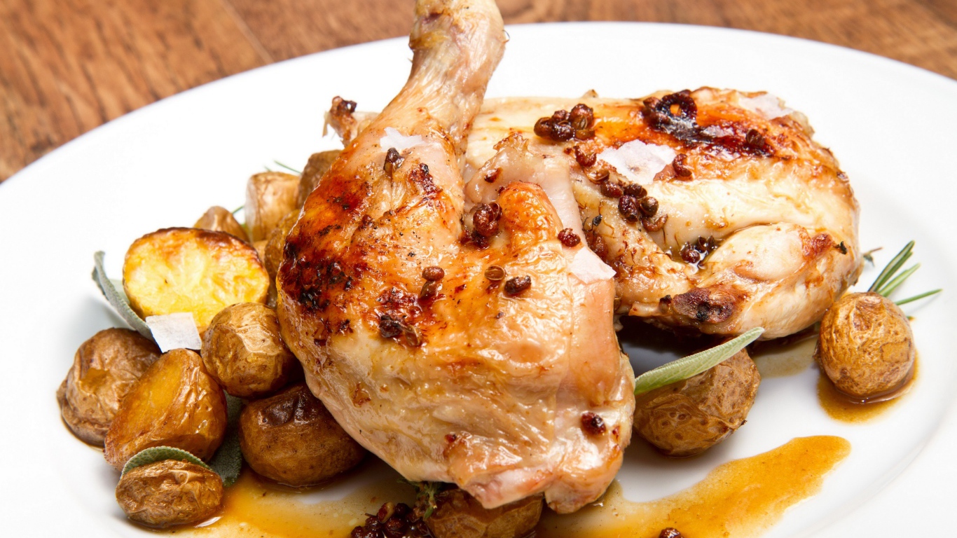 Жареные окорочка с картофелем на белой тарелке