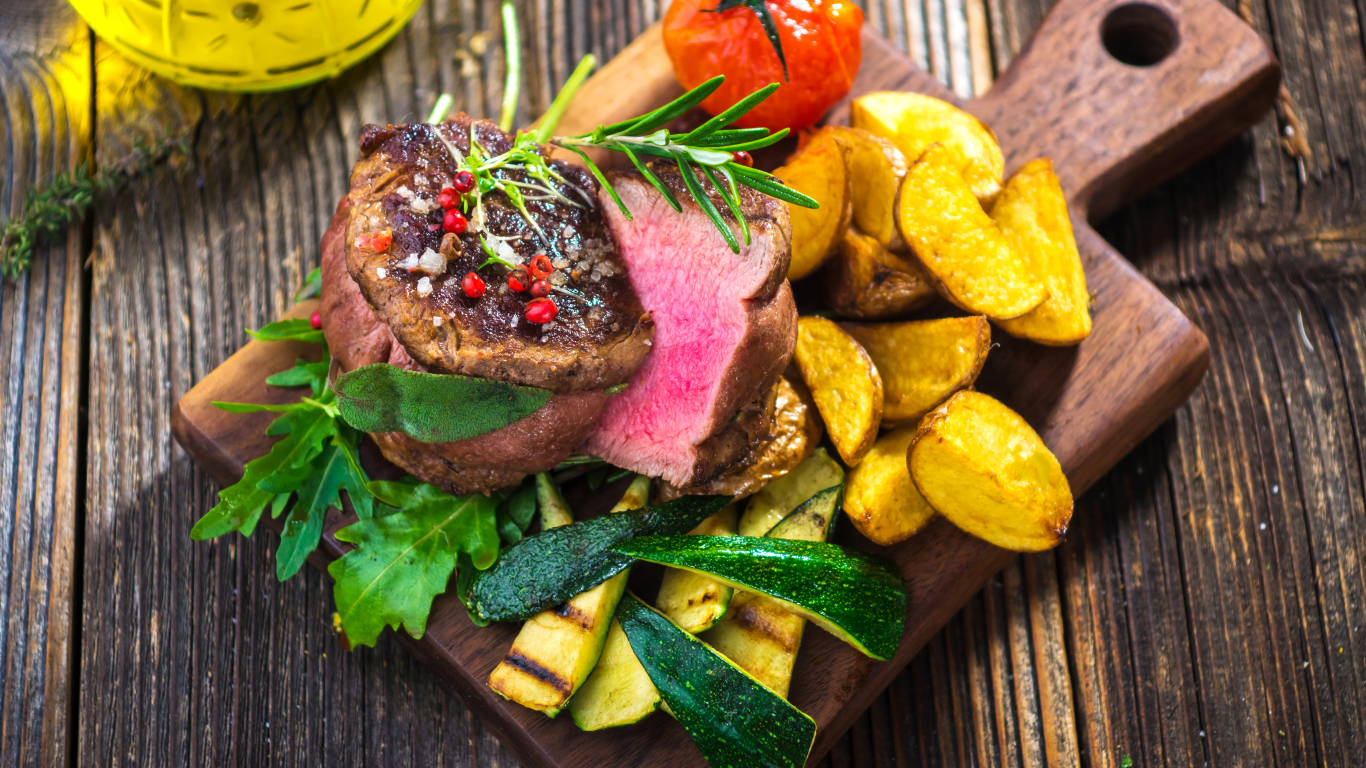 Сочный кусок мяса с картофелем, кабачками и помидорами