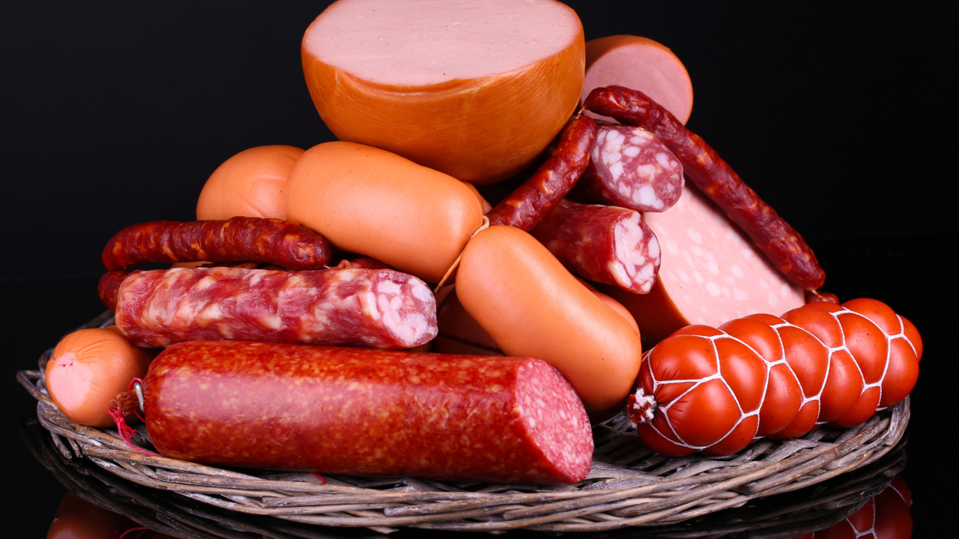 Мясные продукты колбасы и сосиски на черном фоне